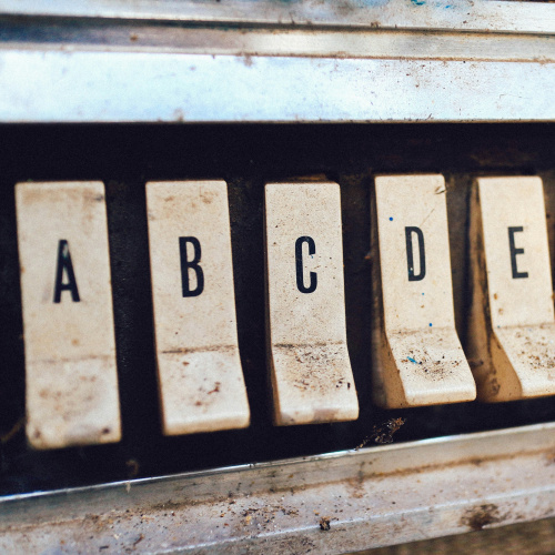 Atēlā redzami pieci dzeltenīgi taustiņi uz katra iespiests viens burts - A B C D E.