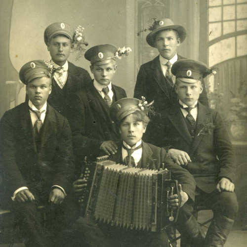 5 latvie&scaron;u strēlnieki, 3 aizmugurē stāv, divi priek&scaron;ā sēž.