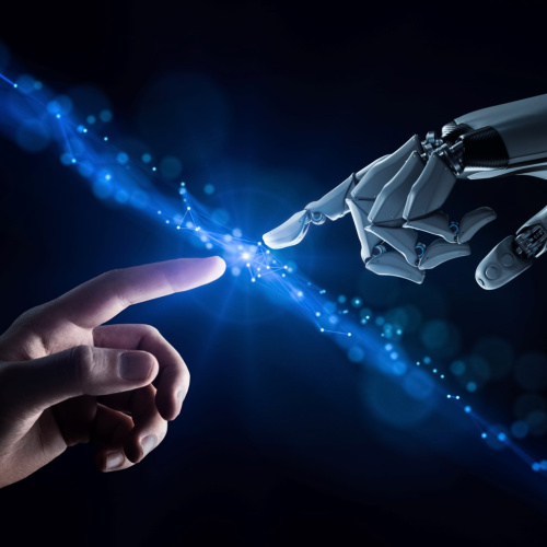 Attēlota cilvēka un robota roka, kuras satiekas līdzīgā veidā kā Mikelandželo gleznā "Ādama radī&scaron;ana".