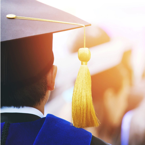 Students ar augstskolas beidzēja cepuri (ar dzeltenu pu&scaron;ķi).