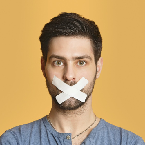 Uz dzeltena fona vīrie&scaron;a seja ar aizlīmētu muti.