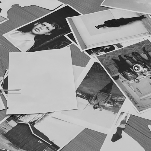 Uz galda izklātas dažādas melnbaltas fotogrāfijas, kurās redzami cilvēki, ainavas un interjeri. Daži attēli ir apgriezti otrādi vai pārklājas cits ar citu. Viena no fotogrāfijām attēlo zēnu ar nopietnu sejas izteiksmi, citas &ndash; cilvēkus dažādās pozās vai vēsturiskos apstākļos.