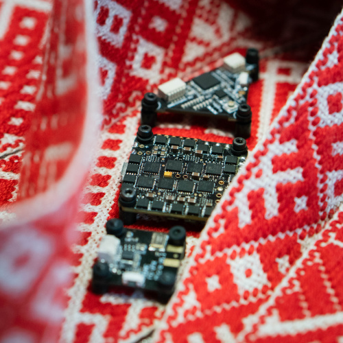 Lielvārdes josta, uz kuras ir novietotas elektrokomponentes, simbolizējot STEM un kultūrizglītības jomas saplū&scaron;anu.